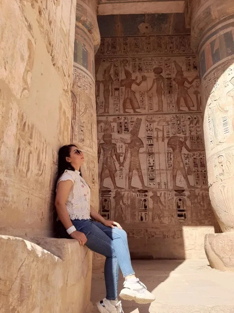 د. رنا مسعد داخل معبد مصري، بين الأعمدة والنقوش القديمة.
